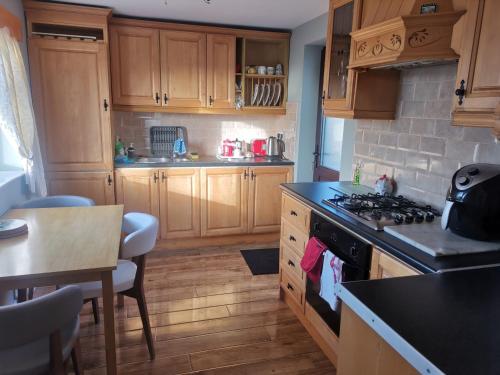 a kitchen with wooden cabinets and a stove top oven at Tranquil unit close to Kells in Kilkenny