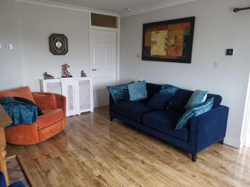 a living room with a blue couch and two chairs at Tranquil unit close to Kells in Kilkenny