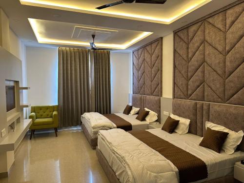 a hotel room with two beds and a television at Click Hotel Narayana in Ayodhya