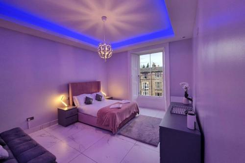 een paarse slaapkamer met een bed en een raam bij Spacious modern city centre apartment Castle Views in Edinburgh