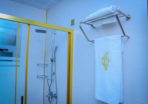 a bathroom with a shower and a towel at Jees Hotel in Hargeysa