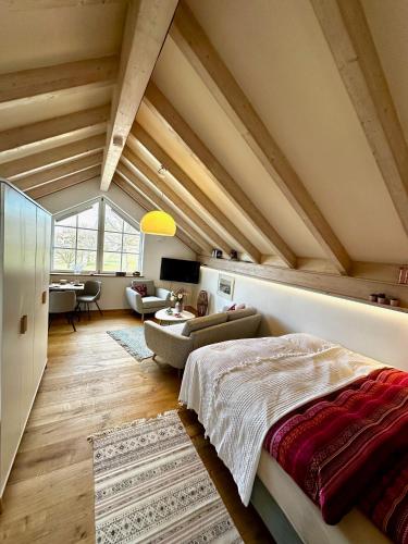 an attic bedroom with a bed and a living room at La Vie en rose in Greifenberg