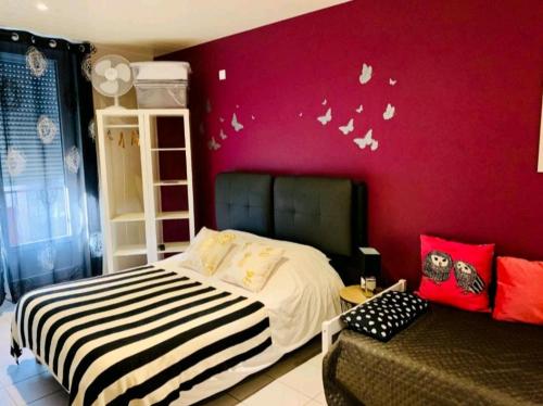 1 dormitorio con cama y pared roja en Escal Evasion, en Auzances
