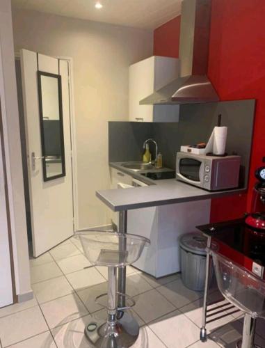 une petite cuisine avec un comptoir et un four micro-ondes dans l'établissement Escal Evasion, à Auzances