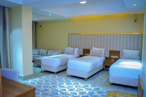 a living room with white couches and a table at Jees Hotel in Hargeysa