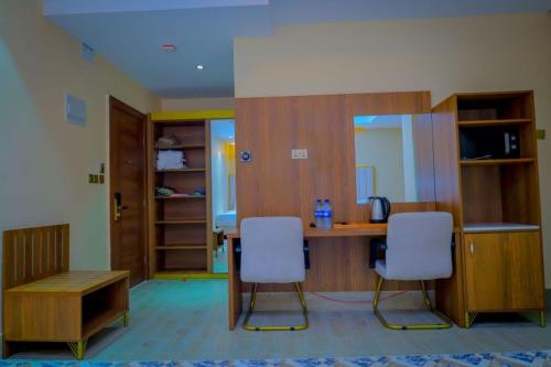 a kitchen with a table and two chairs in a room at Jees Hotel in Hargeysa