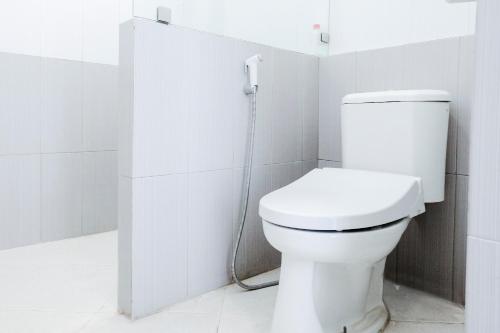 a bathroom with a white toilet in a stall at OYO 1194 Villa Bukit Panderman Residence in Tlekung