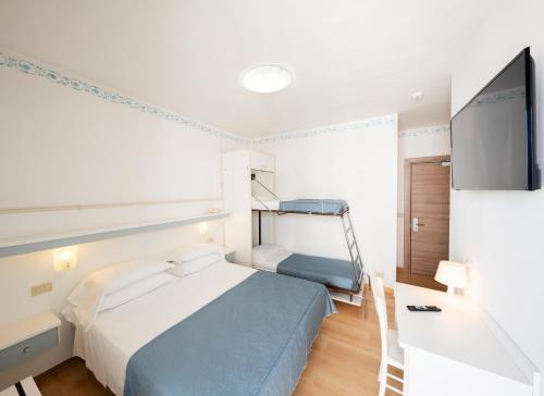 a bedroom with a bed and a tv in it at Hotel Laurin in Lido di Jesolo