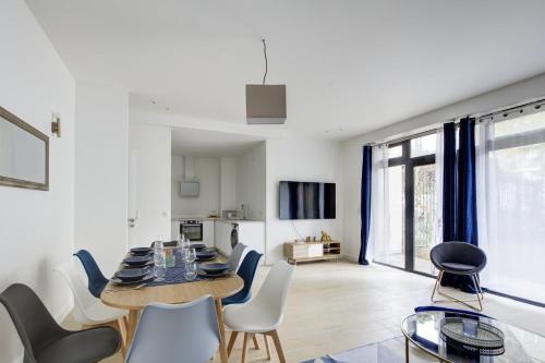 a dining room and living room with a table and chairs at 328 Suite Nathaniel - Superb apartment in Paris in Saint-Mandé