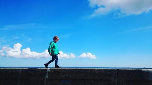 a man walking on a wall with a blue sky at Jalebo in Cleethorpes