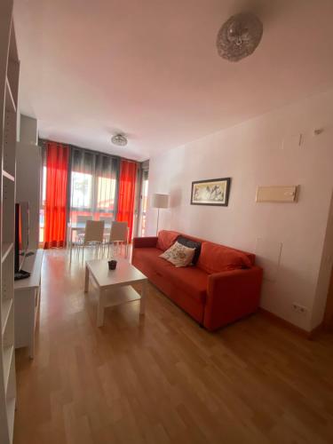 sala de estar con sofá rojo y mesa en Excelente apartamento en Benimaclet, en Valencia