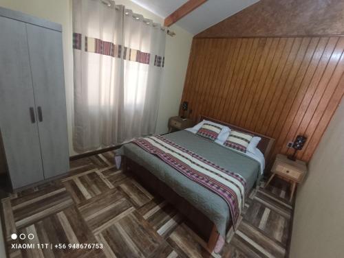 a bedroom with a bed with a wooden headboard at Cabañas Atahualpa in Pica