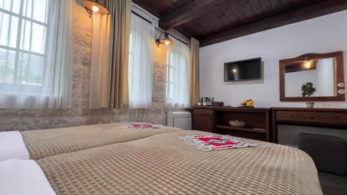 a bedroom with a bed and a tv on the wall at Stara Čaršija Hotel & SPA in Bar