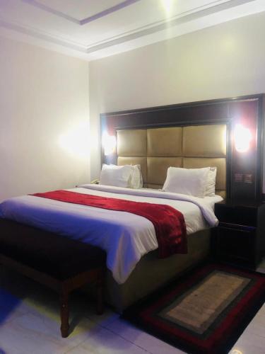 um quarto com uma cama grande e um cobertor vermelho em MCLORRETS SUITES em Enugu