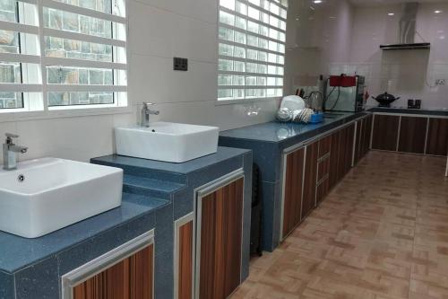 un bagno con due lavandini su un bancone blu di Semi-detached House, Semenyih, Malaysia a Semenyih