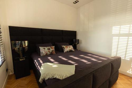 a bedroom with a large bed with a large headboard at Spacious private apartement, 25min from Amsterdam in Hilversum