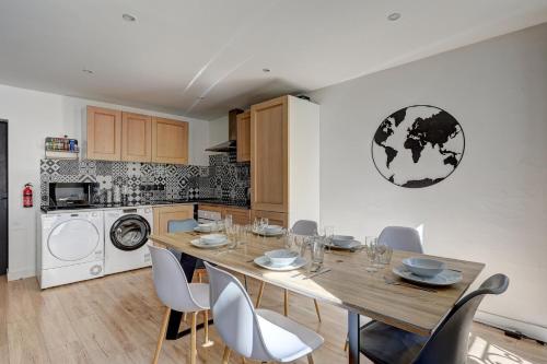 a kitchen with a wooden table and chairs in a room at 127 Suite Moshé - Superbe Appartement à Paris. in Paris