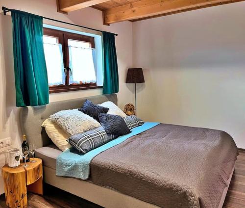 sypialnia z dużym łóżkiem z zielonymi zasłonami w obiekcie Chata u Hrušků 100m od sjezdovky w mieście Orawska Leśna