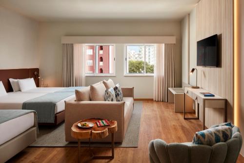um quarto de hotel com uma cama e um sofá em Dom Jose Beach Hotel (Plus) em Quarteira