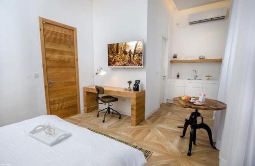 a bedroom with a bed and a desk and a table at לוויט האוס in Poriyya Illit