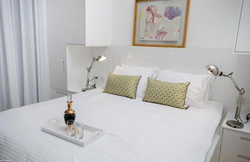 un letto bianco con due lampade e una bottiglia sopra di לוויט האוס a Poriyya