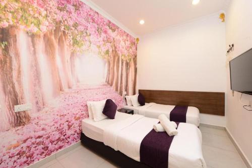 two beds in a room with a flower mural at Seeds Hotel Shah Alam Section 19 in Shah Alam