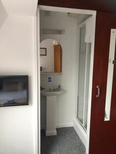 a bathroom with a sink and a mirror at Fairways Guest House in Cambridge