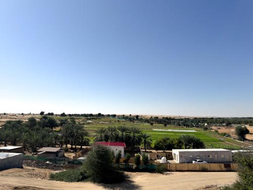 a village in the desert with palm trees and buildings at Lehbab Star Residence - Home Stay in Dubai