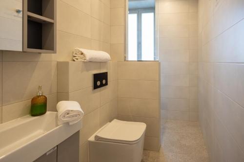 La salle de bains blanche est pourvue de toilettes et d'un lavabo. dans l'établissement Marina View 34, à Il-Birgu
