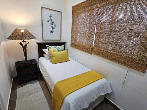 a small bedroom with a bed and a window at Leopard Corner Lodge in St Lucia