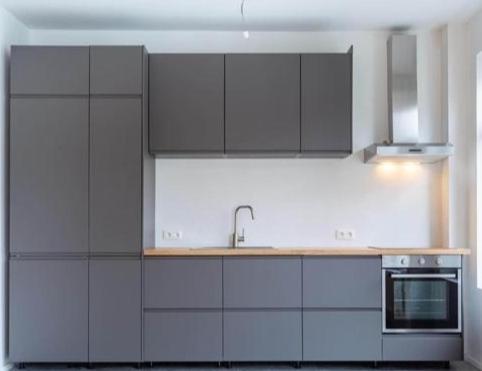 een keuken met witte kasten en een wastafel bij Appartement Sportpaleis in Antwerpen