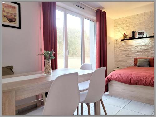 a bedroom with a table and chairs and a bed at Salle de jeux enfant 10min de disney transport en commun 1 chambre 4 couchages et 2 dans le salon in Chanteloup-en-Brie
