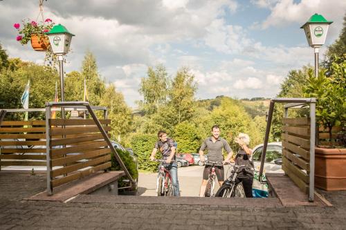 a group of people riding bikes on a bridge at Waldhotel Felschbachhof in Ulmet