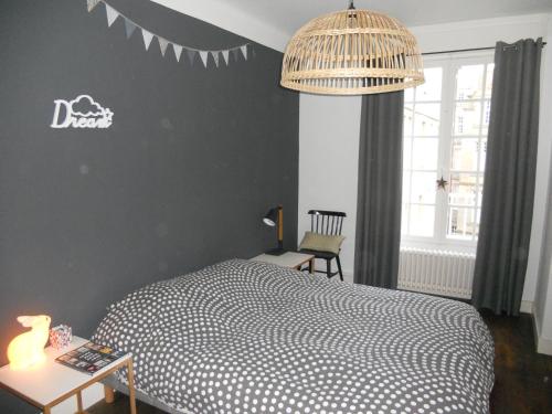 een slaapkamer met een bed en een tafel met een lamp bij Le Saint-François in Saint-Malo