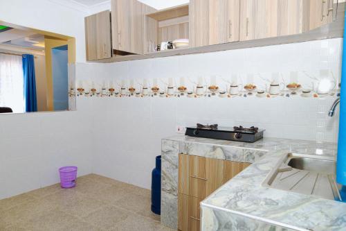 uma cozinha com um lavatório e uma bancada em Gerly Homes Hotel & Restaurant em Kakamega