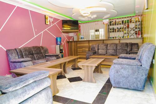 a bar with couches and a table and chairs at Gerly Homes Hotel & Restaurant in Kakamega