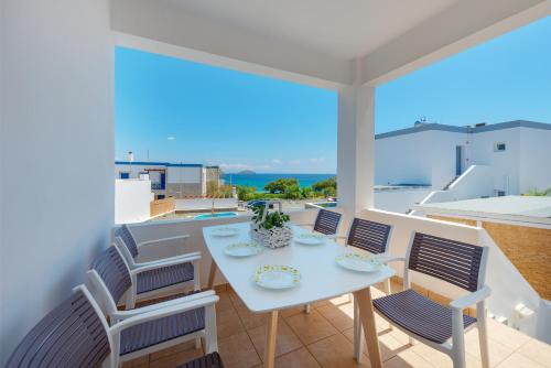 a white table and chairs on a balcony with a view at Aegean Paradiso Vacation Club - "Adults Only" in Azolimnos