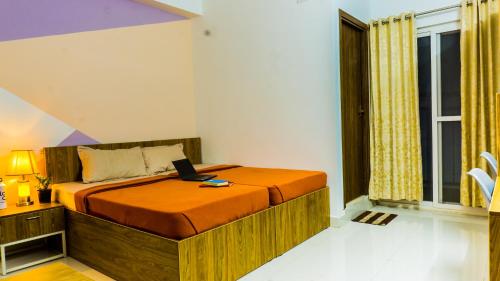 a bedroom with a bed with a laptop on it at Local Colive Sarjapur in Bangalore