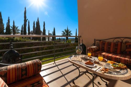 a balcony with a table with food and wine glasses at Encosta da Orada by OCvillas in Albufeira
