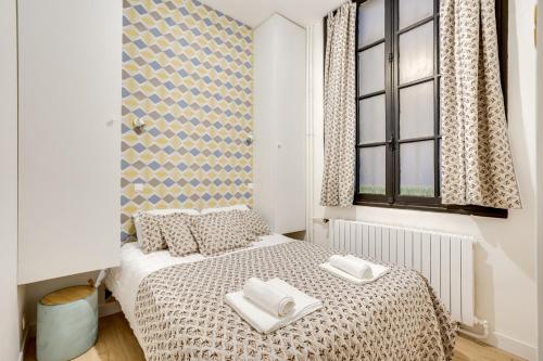 um quarto com uma cama com duas toalhas em 138 Suite Wizman - Superbe Appartement à Paris em Paris