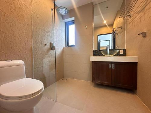 uma casa de banho com um WC, um lavatório e um espelho. em TSE Residence [by Samui Emerald] em Praia de Choeng Mon