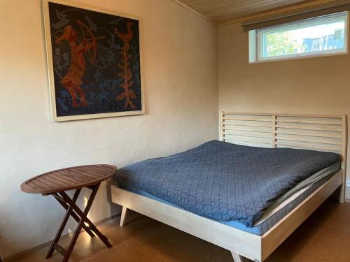 1 dormitorio con cama, mesa y ventana en Garden house near centre en Tampere