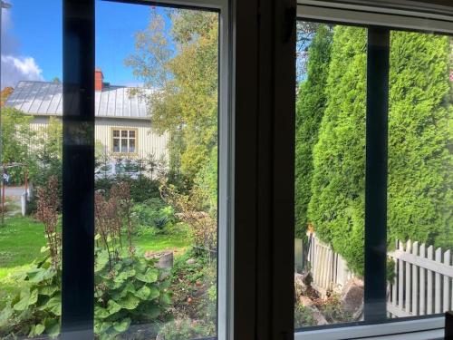 a window with a view of a garden and a house at Garden house near centre in Tampere