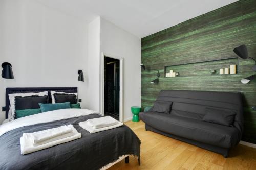 a bedroom with a large bed and a couch at 124 Suite Beata - Superbe Appartement à Paris in Paris