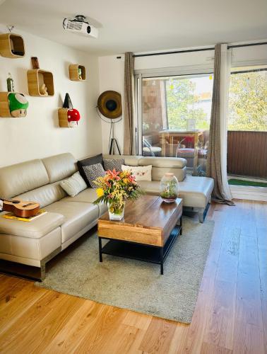 un salon avec un canapé et une table basse dans l'établissement 3' Subway, 15' Center, AC, Parking, Calm, Balcony, aux Lilas