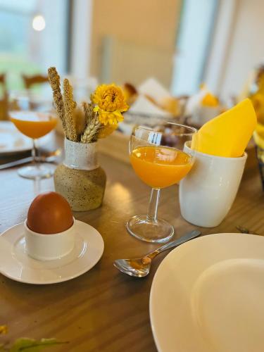 a table topped with plates and glasses of orange juice at De Grote Linde in Oostkamp