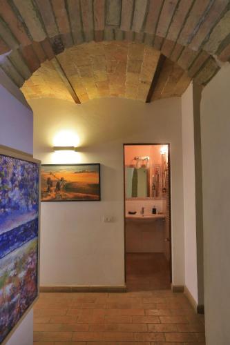 a hallway with a bathroom with a painting on the wall at Corte dei Guelfi in San Gimignano