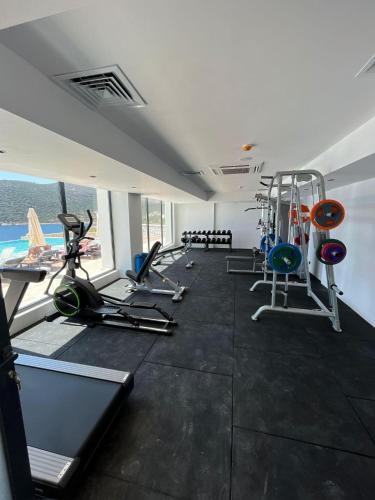 a gym with several treadmills and machines in a room at Lures Hotel in Kalkan