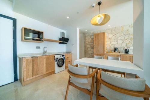 a kitchen with a table and chairs and a sink at Lures Hotel in Kalkan