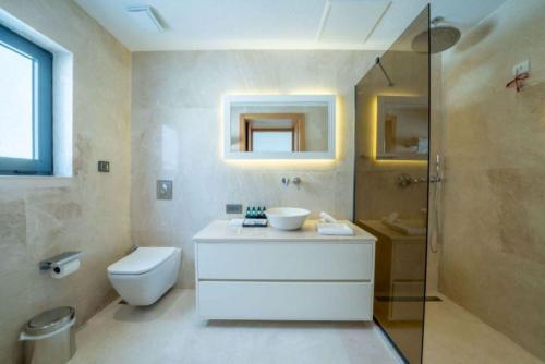 a bathroom with a sink and a toilet and a shower at Lures Hotel in Kalkan
